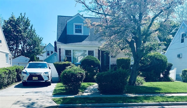 view of front of home with a front yard and roof with shingles