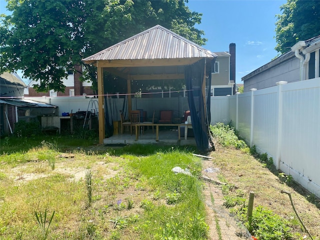 view of outdoor structure with a gazebo and a fenced backyard