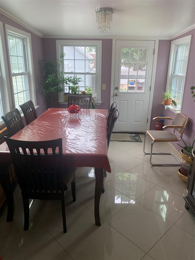 dining room with light tile patterned floors, crown molding, and a chandelier