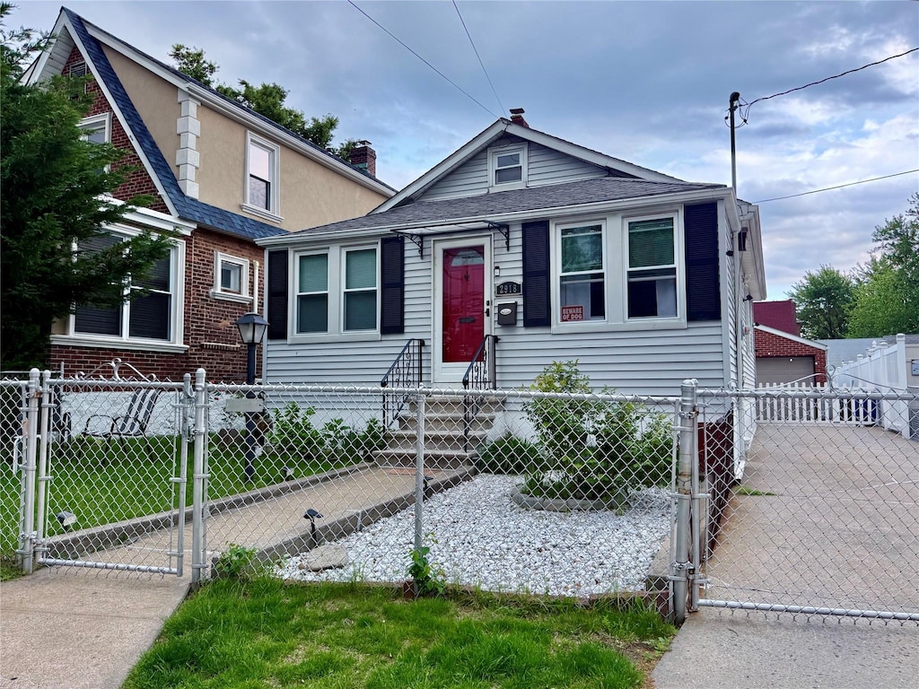 view of front of property featuring a gate, a fenced front yard, entry steps, and a detached garage