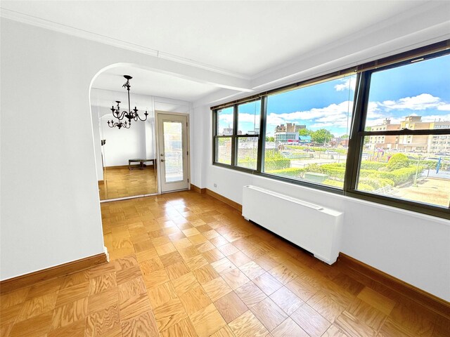 61-20 Grand Central Pkwy Unit B204, Forest Hills, NY 11375 - unfurnished dining area with radiator heating unit, a chandelier, baseboards, and crown molding