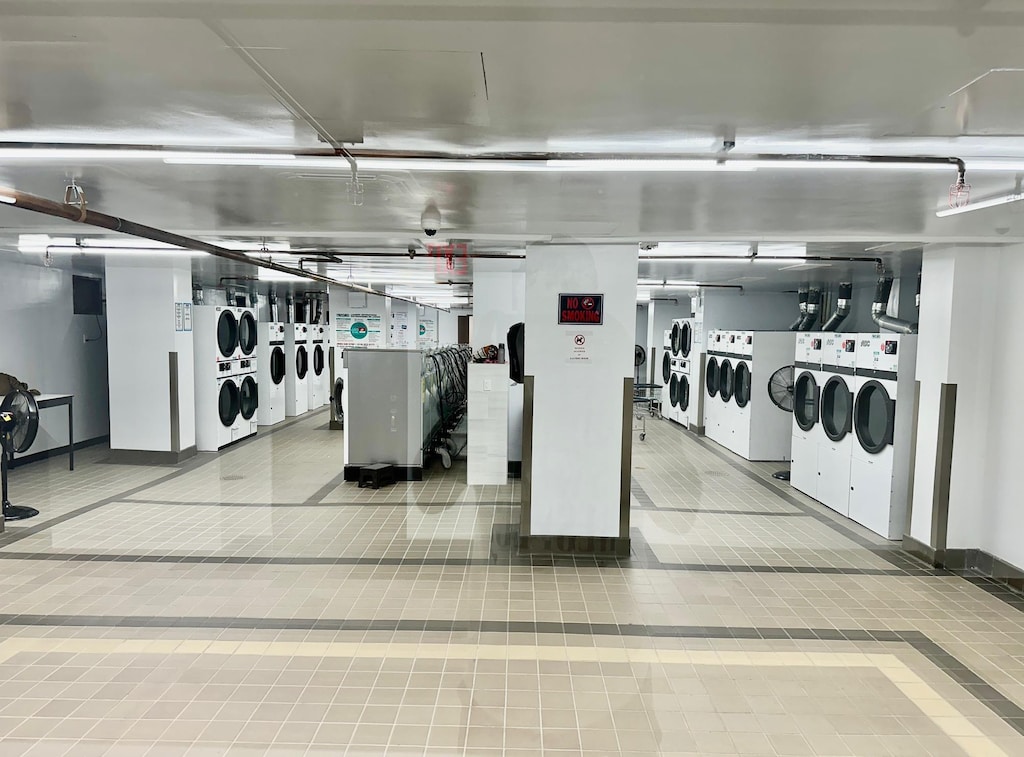 61-20 Grand Central Pkwy Unit B204, Forest Hills, NY 11375 - interior space with washing machine and dryer, stacked washer / drying machine, and baseboards
