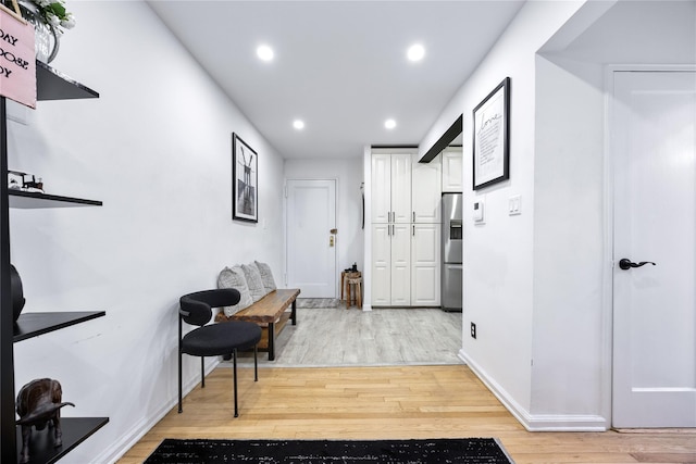 hall featuring recessed lighting, light wood-style floors, and baseboards