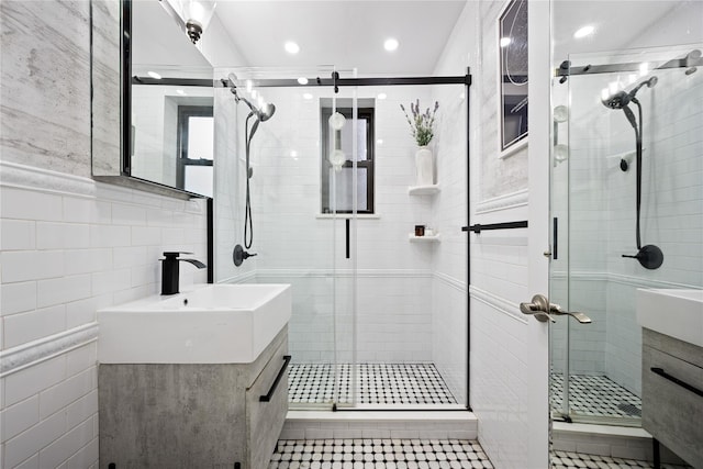 bathroom with vanity, a stall shower, tile walls, tile patterned flooring, and recessed lighting