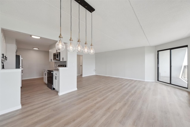 400 High Point Dr Unit 313, Hartsdale, NY 10530 - kitchen featuring black electric range, stainless steel microwave, baseboards, light wood-type flooring, and a textured ceiling