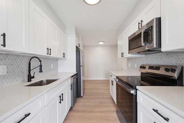 400 High Point Dr Unit 313, Hartsdale, NY 10530 - kitchen with stainless steel appliances, a sink, white cabinets, and backsplash