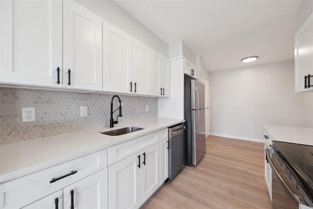 400 High Point Dr Unit 313, Hartsdale, NY 10530 - kitchen with a sink, appliances with stainless steel finishes, light countertops, white cabinets, and decorative backsplash