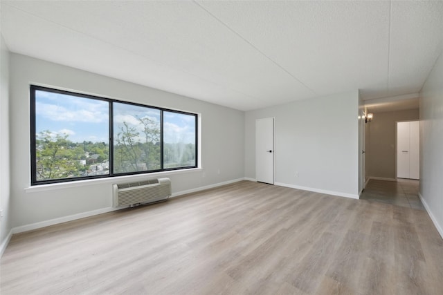 400 High Point Dr Unit 313, Hartsdale, NY 10530 - unfurnished room with a wall mounted AC, light wood-style flooring, a chandelier, and baseboards