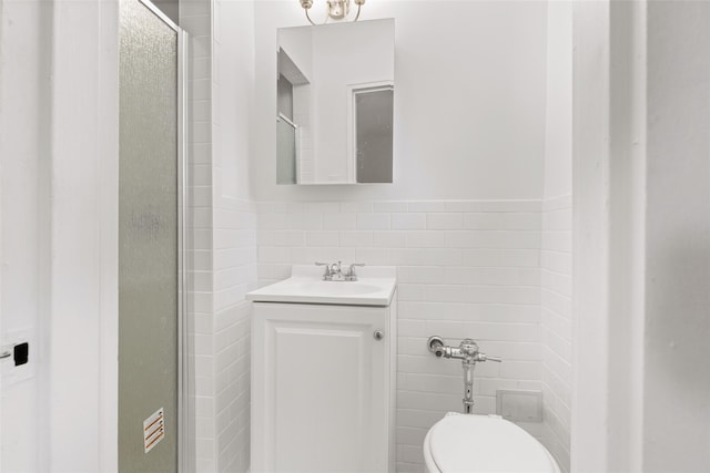 full bathroom with tile walls, vanity, toilet, and a shower with door