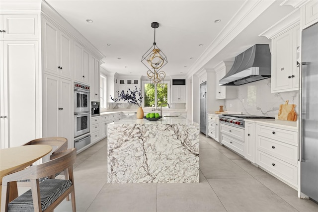 7 Beverly Rd, Kensington, NY 11021 - kitchen featuring wall chimney range hood, appliances with stainless steel finishes, a warming drawer, white cabinets, and a sink