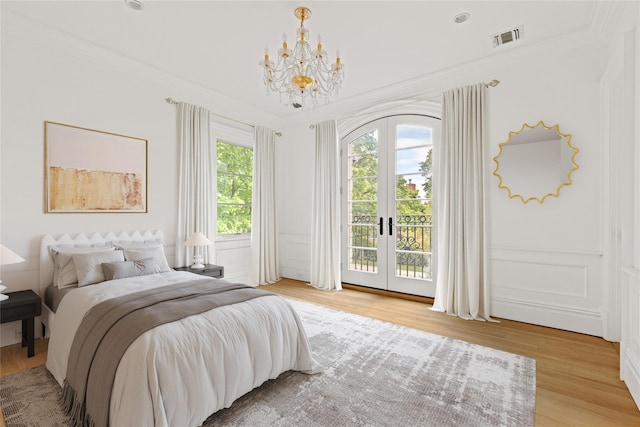 7 Beverly Rd, Kensington, NY 11021 - bedroom featuring access to exterior, french doors, a chandelier, crown molding, and light wood-style flooring