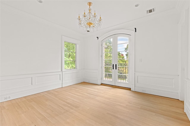 7 Beverly Rd, Kensington, NY 11021 - spare room featuring french doors, a chandelier, a decorative wall, crown molding, and light wood-style flooring
