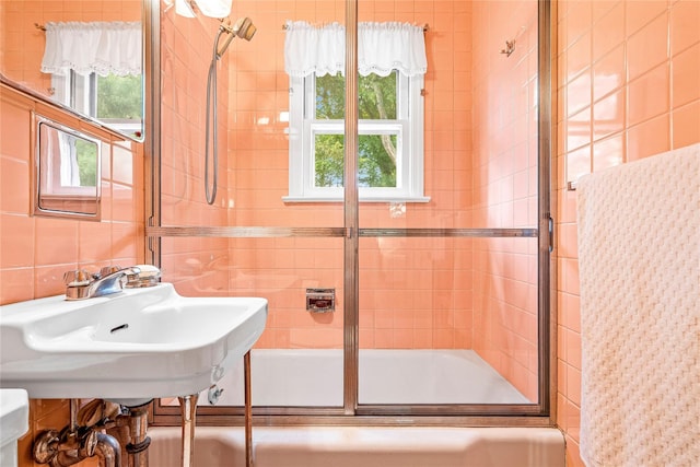 63 Lexington Dr, Croton-On-Hudson, NY 10520 - bathroom with healthy amount of natural light, tile walls, bath / shower combo with glass door, and a sink