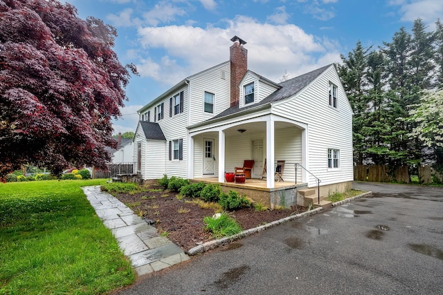 view of side of property featuring covered porch and a chimney