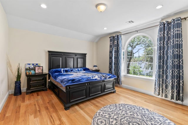 bedroom with baseboards, light wood-type flooring, recessed lighting, and vaulted ceiling