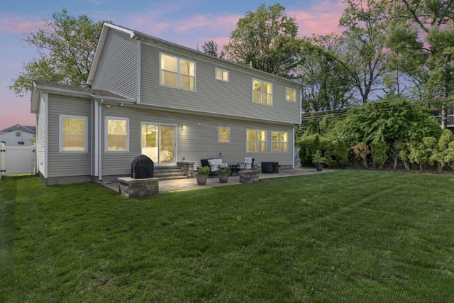 back of property with entry steps, a patio area, and a yard