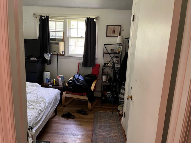 11 Acorn Ln, Stony Brook, NY 11790 - bedroom with wood finished floors, cooling unit, and a baseboard radiator