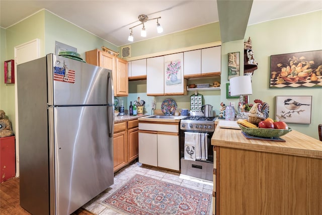100 S Ocean Ave Unit 2E, Freeport, NY 11520 - kitchen with stainless steel appliances, open shelves, butcher block counters, white cabinetry, and light tile patterned floors