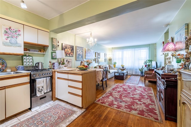 100 S Ocean Ave Unit 2E, Freeport, NY 11520 - kitchen featuring light wood-type flooring, gas range, and a chandelier