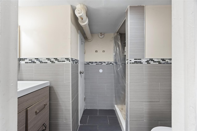 175 N Columbus Ave, Freeport, NY 11520 - full bathroom with tile walls, vanity, a shower stall, tile patterned flooring, and toilet