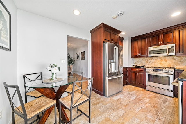 kitchen featuring stainless steel appliances, decorative backsplash, recessed lighting, and dark countertops