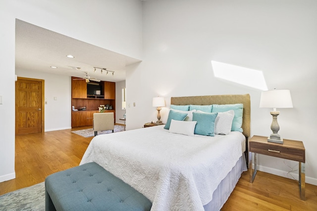 bedroom with baseboards and light wood finished floors