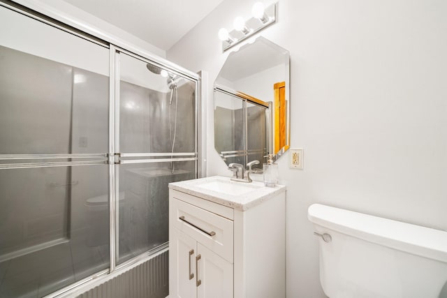 bathroom with toilet, an enclosed shower, and vanity