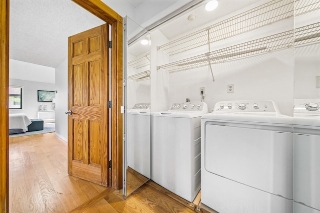 washroom featuring washer and clothes dryer and light wood finished floors