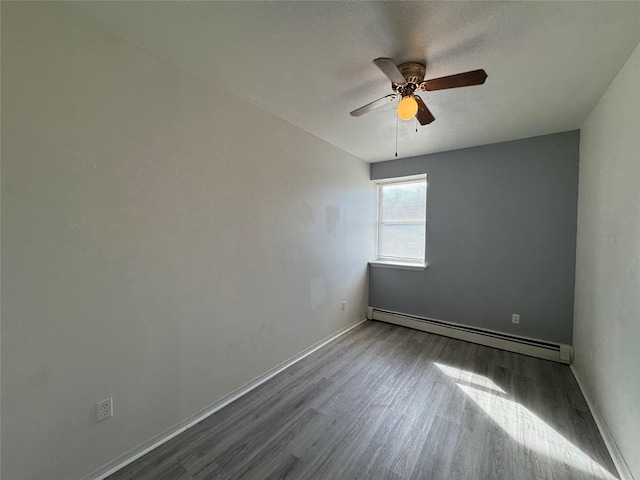 unfurnished room featuring a baseboard heating unit, wood finished floors, ceiling fan, and baseboards