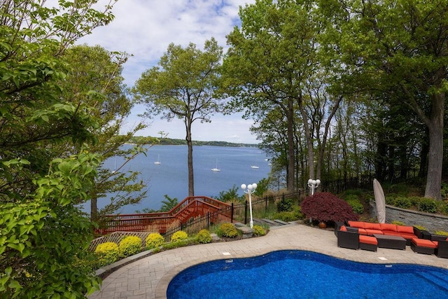 view of pool with an outdoor hangout area, a water view, a patio area, and fence
