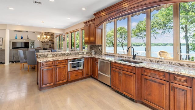 12 Sunset Path, Port Jefferson, NY 11777 - kitchen featuring a sink, appliances with stainless steel finishes, a chandelier, a peninsula, and brown cabinetry