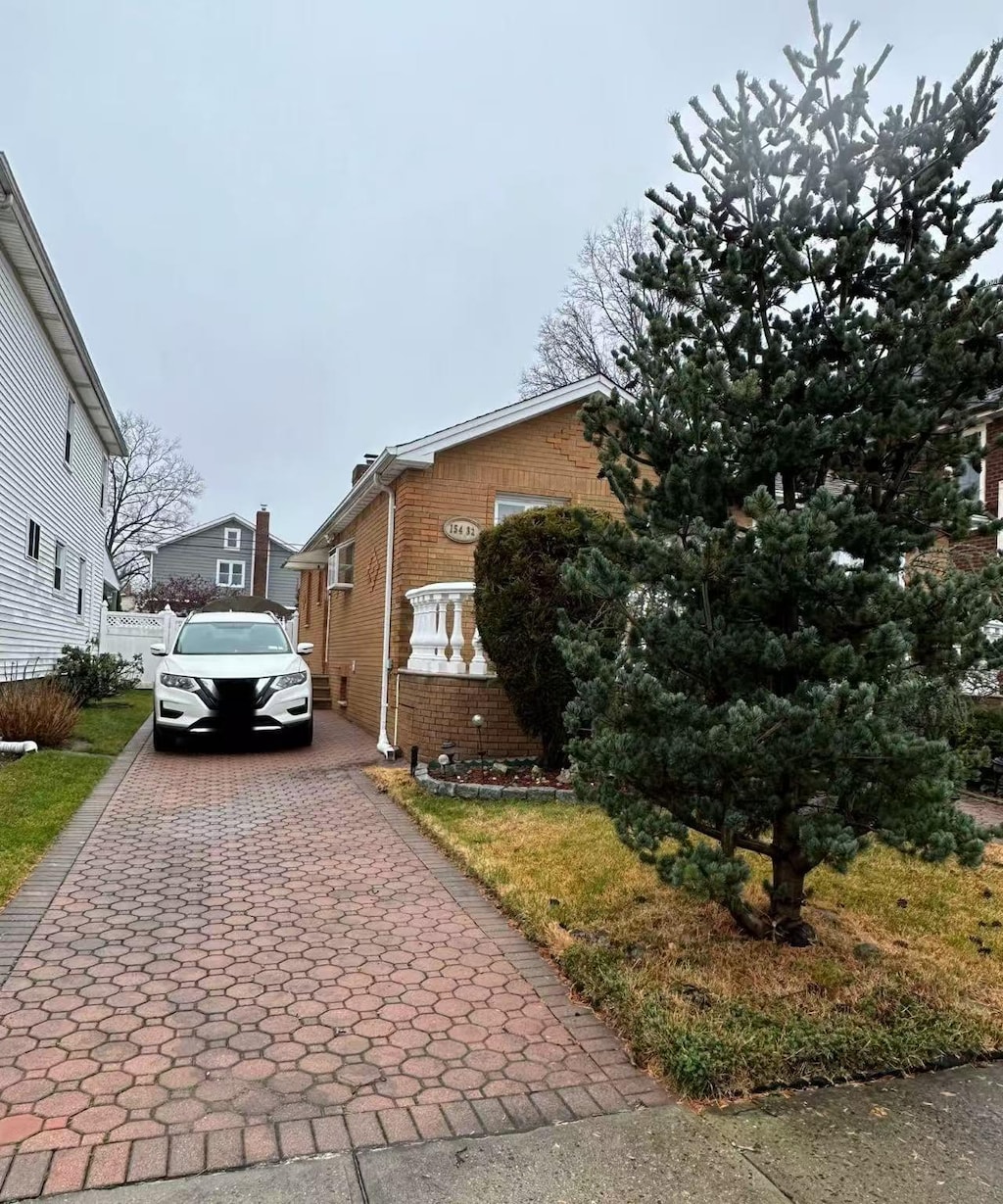 view of property exterior with brick siding and driveway