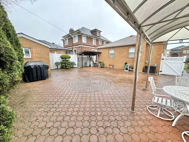 view of patio with a gate, grilling area, fence, and central AC