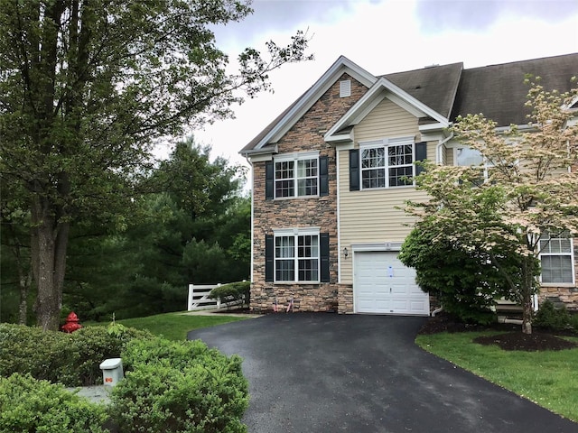 view of front of house with stone siding, asphalt driveway, and an attached garage