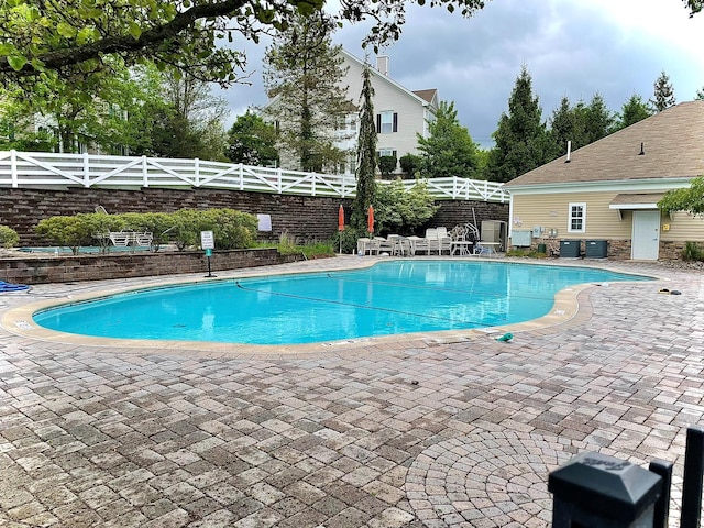 view of swimming pool featuring a patio area, a fenced backyard, and central AC
