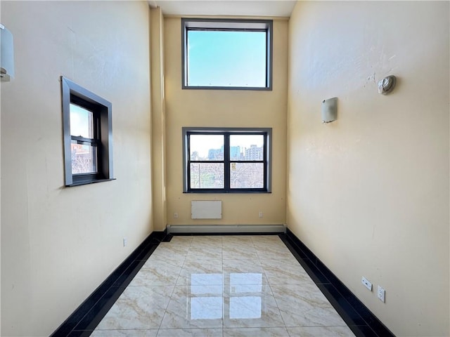 unfurnished room with baseboards and dark marble finish flooring