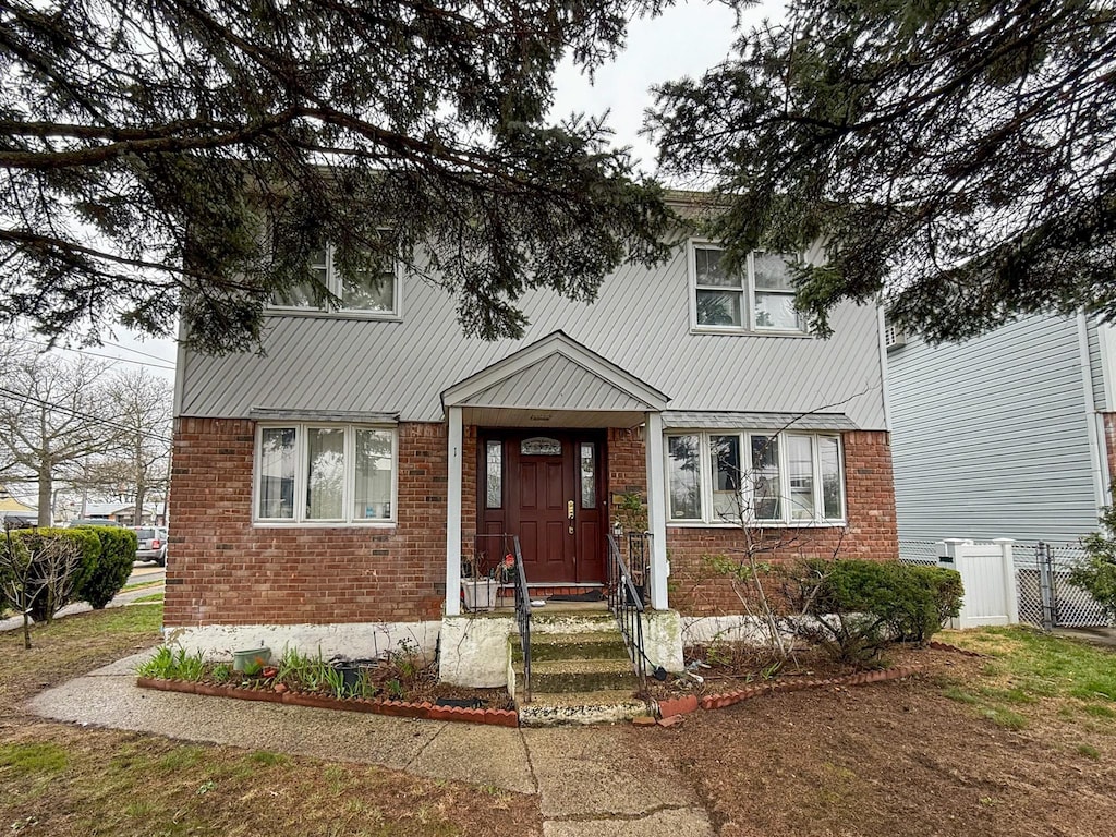 view of front of property featuring brick siding and fence