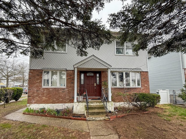 view of front of property featuring brick siding and fence