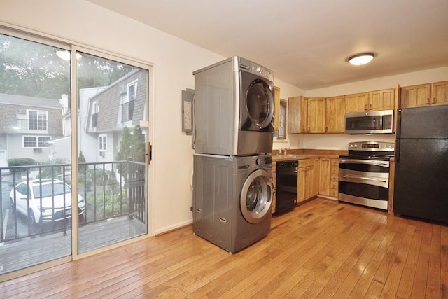 11 The Blvd Unit A4, Cold Spring, NY 10516 - kitchen with black appliances, estacked washer and dryer, a sink, light wood-type flooring, and healthy amount of natural light