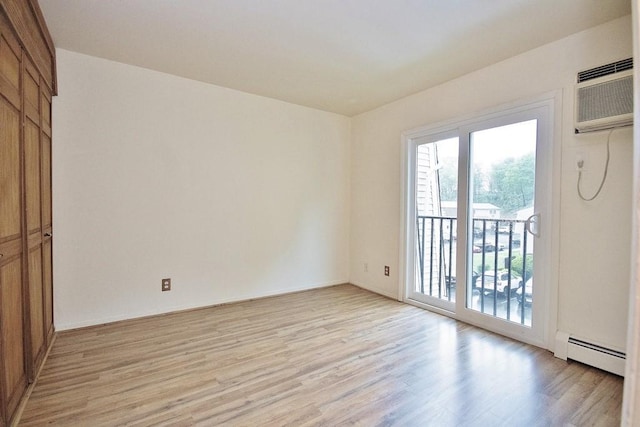 11 The Blvd Unit A4, Cold Spring, NY 10516 - unfurnished room with a baseboard radiator, light wood-style flooring, healthy amount of natural light, and a wall mounted AC