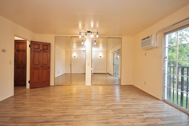 11 The Blvd Unit A4, Cold Spring, NY 10516 - unfurnished room with light wood finished floors, a wall unit AC, and baseboards