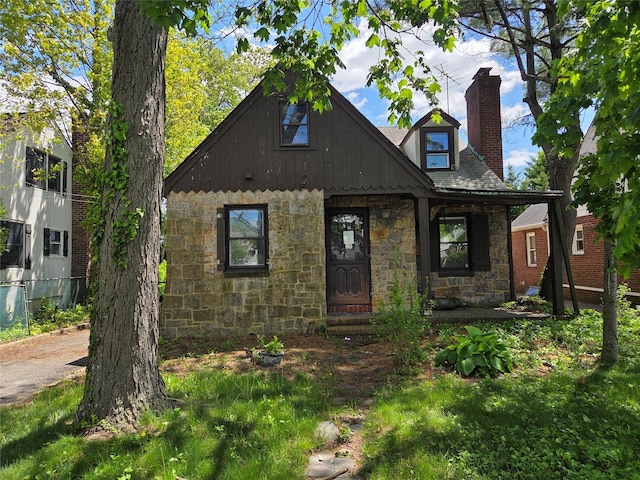 view of front of property featuring stone siding and a chimney