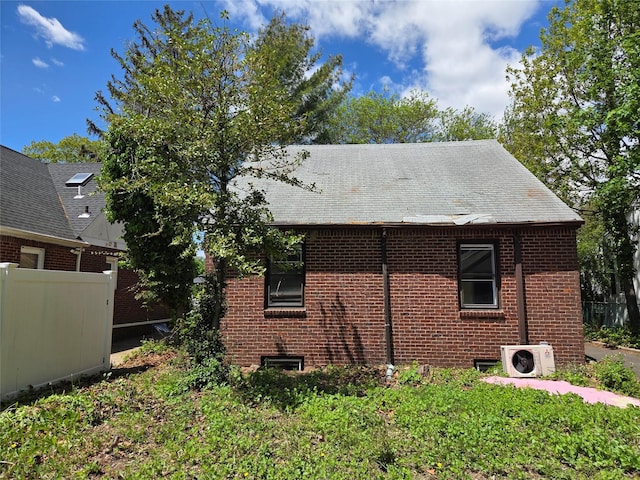 view of home's exterior with a cooling unit, brick siding, and fence