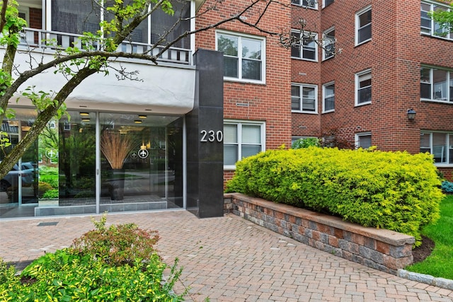 entrance to property featuring brick siding