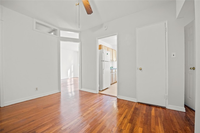 empty room with light wood-type flooring, ceiling fan, and baseboards