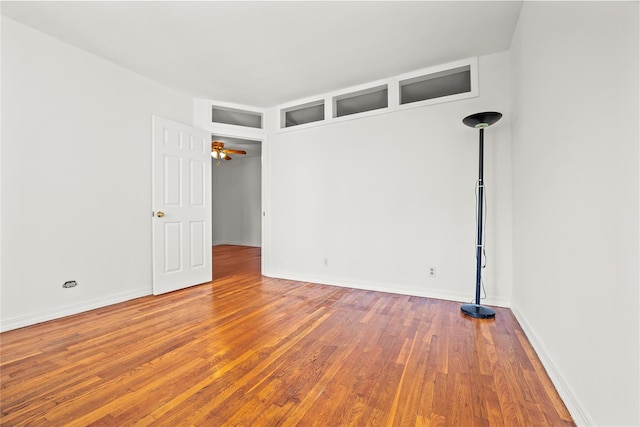 unfurnished room with wood finished floors and baseboards