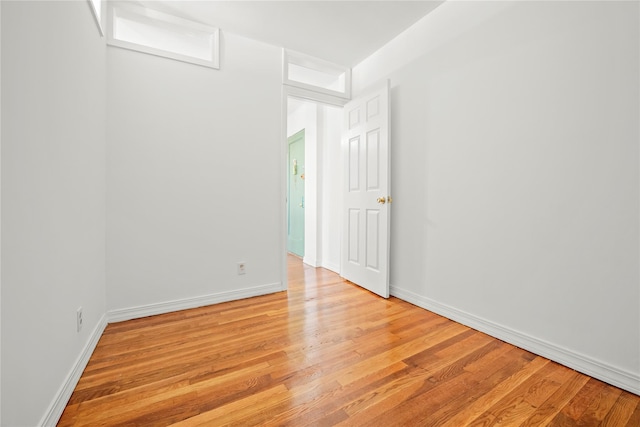 spare room with light wood-style floors and baseboards