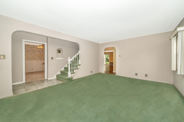 11 Durham Rd, New Hyde Park, NY 11040 - unfurnished living room with arched walkways, stairs, baseboards, light carpet, and light tile patterned floors