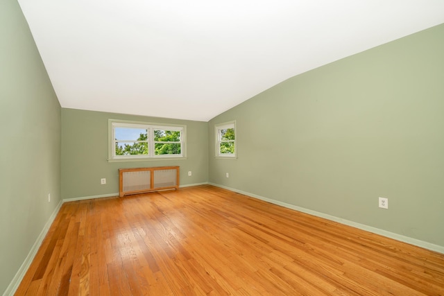11 Durham Rd, New Hyde Park, NY 11040 - empty room featuring radiator heating unit, light wood finished floors, lofted ceiling, and baseboards