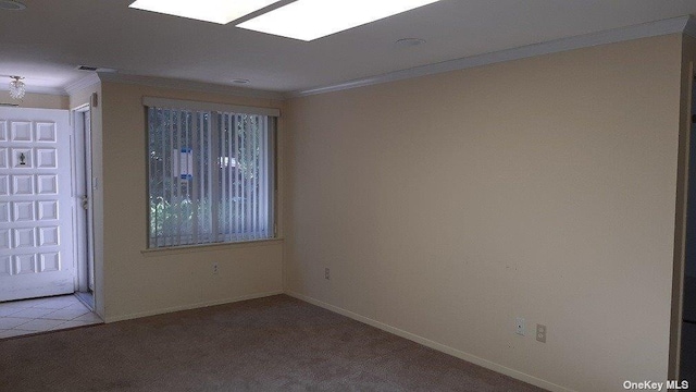 unfurnished room with crown molding, light colored carpet, and baseboards